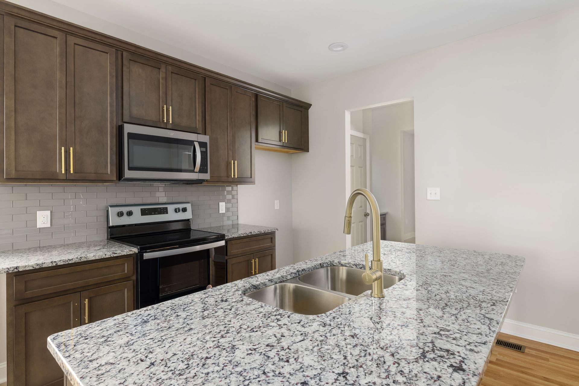 Elegant modern kitchen featuring a marble countertop, stainless steel appliances, and wooden cabinets.