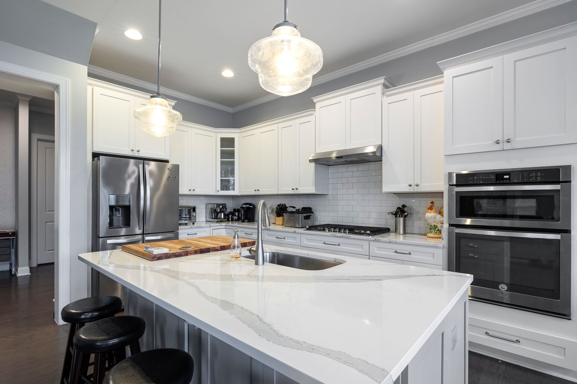 Spacious contemporary kitchen with marble island and stainless steel appliances.